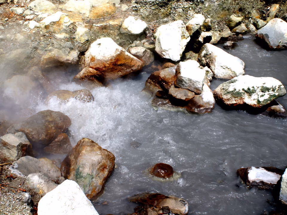 Caldeira geotérmica borbulhando entre rochas em Furnas, ilha de São Miguel, Açores