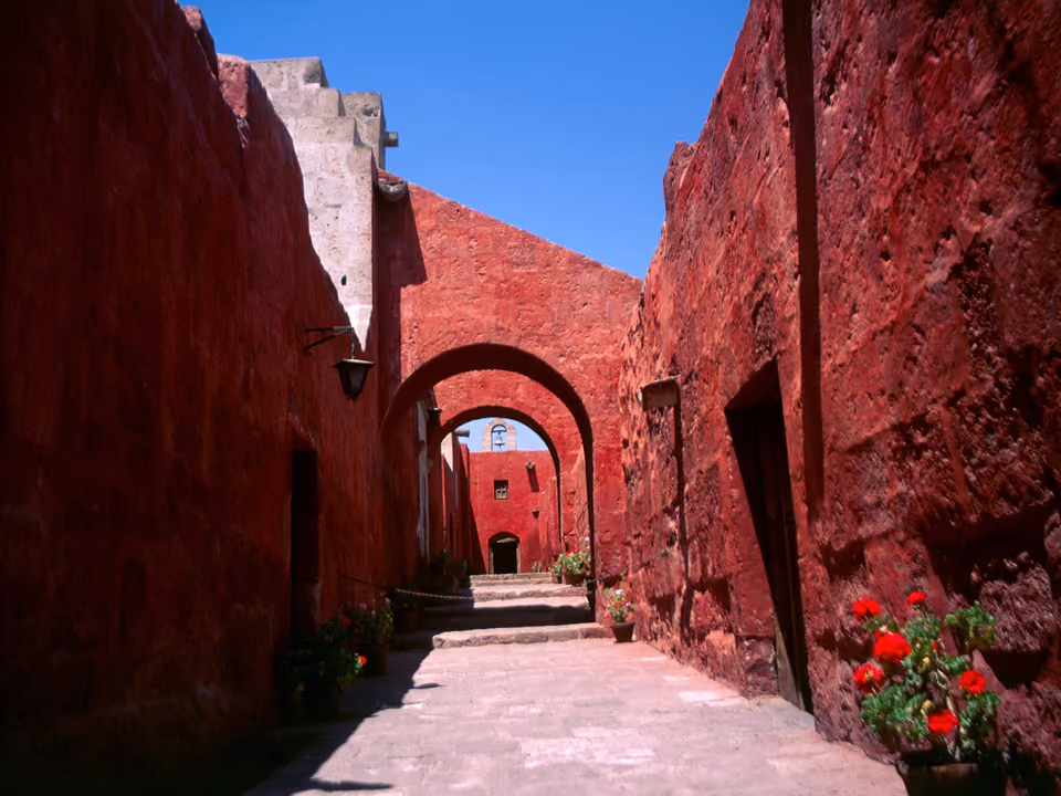Corredor de arcos em tom vermelho dentro do Monasterio de Santa Catalina, Arequipa, Peru