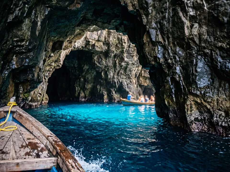 Interior da Gruta Azul visto de barco, com a luz do sol tingindo a água de azul elétrico