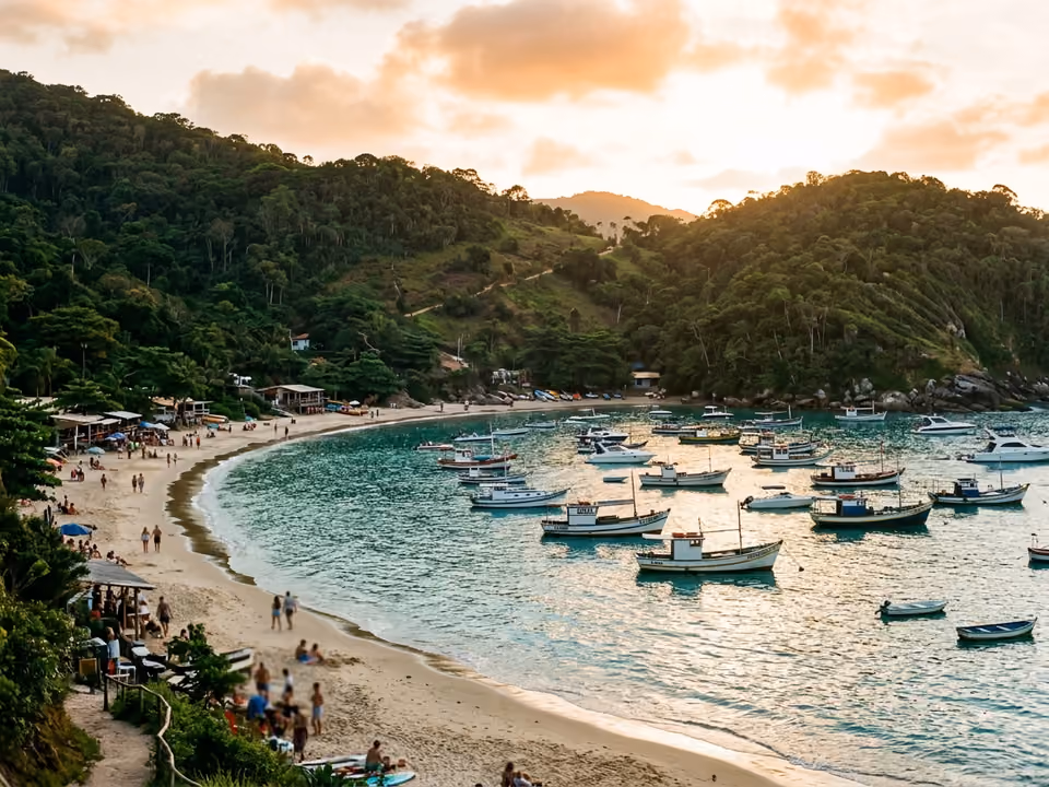 Enseada de Laranjeiras com água calma, barcos ancorados e morros de mata ao redor