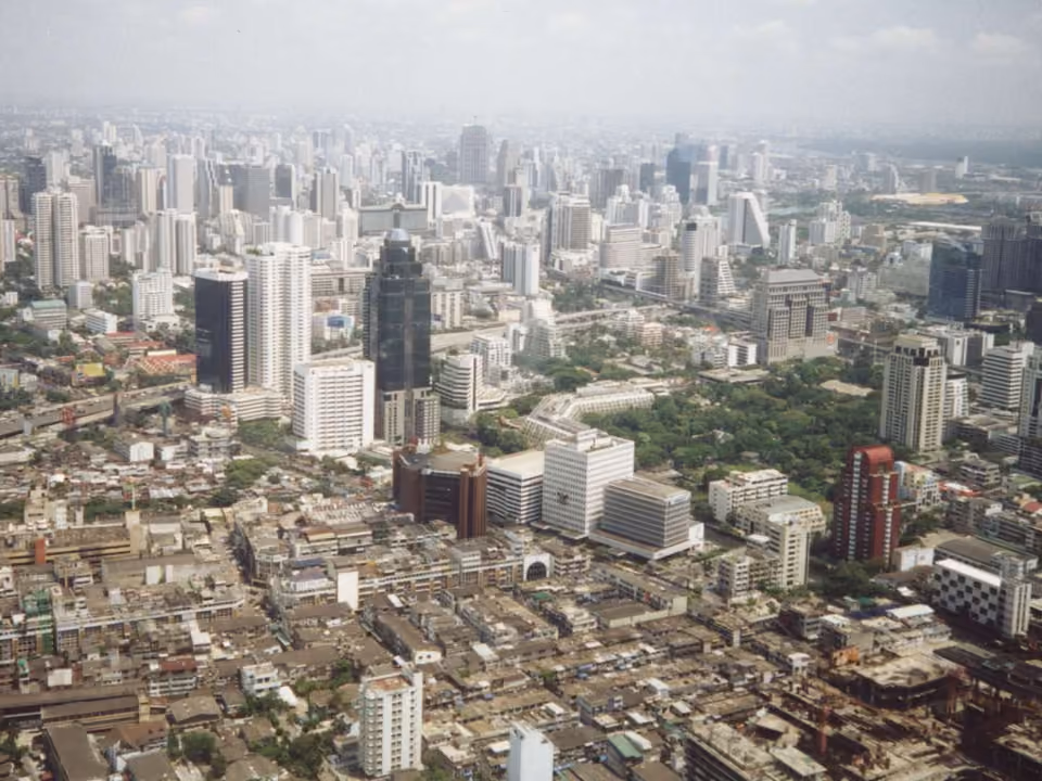 Vista aérea do horizonte de Bangkok, com prédios e área verde do Lumphini Park ao fundo