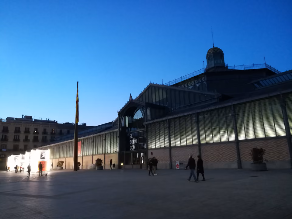 O antigo Mercat del Born, hoje o centro cultural El Born CCM, no bairro do Born em Barcelona — a estrutura de ferro e vidro do século XIX iluminada ao entardecer, a poucos metros do Museu Picasso