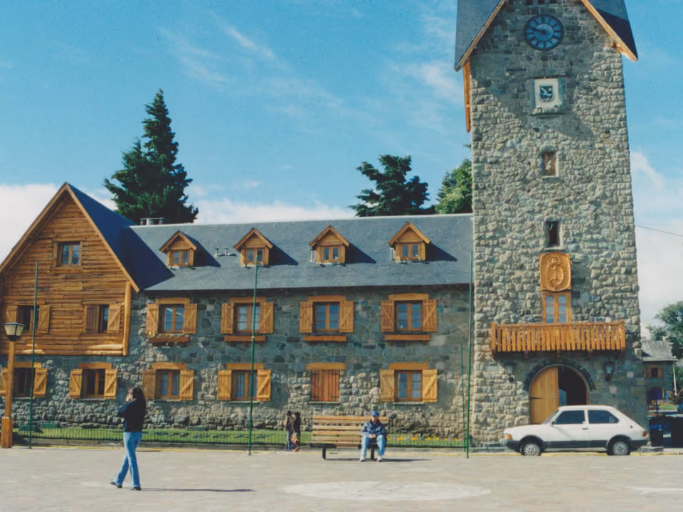 Centro Cívico de Bariloche, praça de pedra com prédios em estilo alpino e a estátua de São Bernardo, à beira do Lago Nahuel Huapi