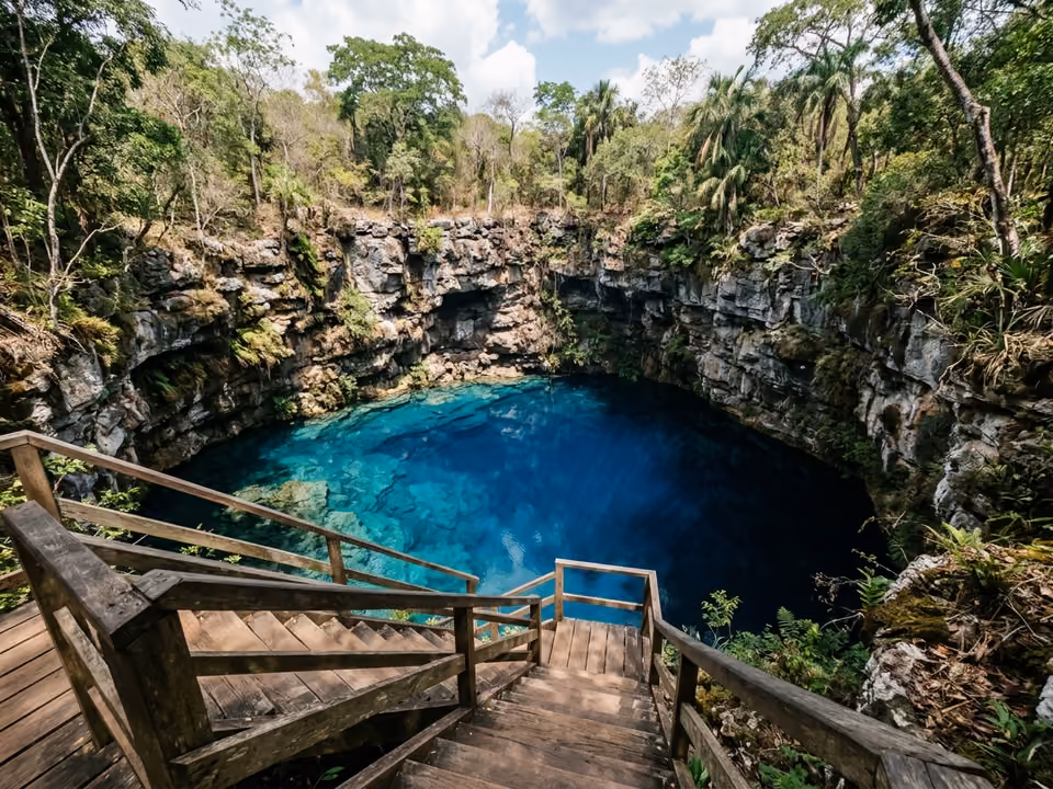 Superfície azul-escura da Lagoa Misteriosa cercada por paredões de rocha e mata, com plataforma de mergulho na borda
