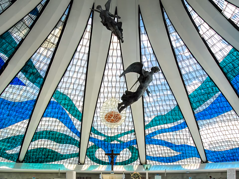 Interior iluminado da Catedral Metropolitana de Brasília, com vitrais azuis no teto em forma de coroa