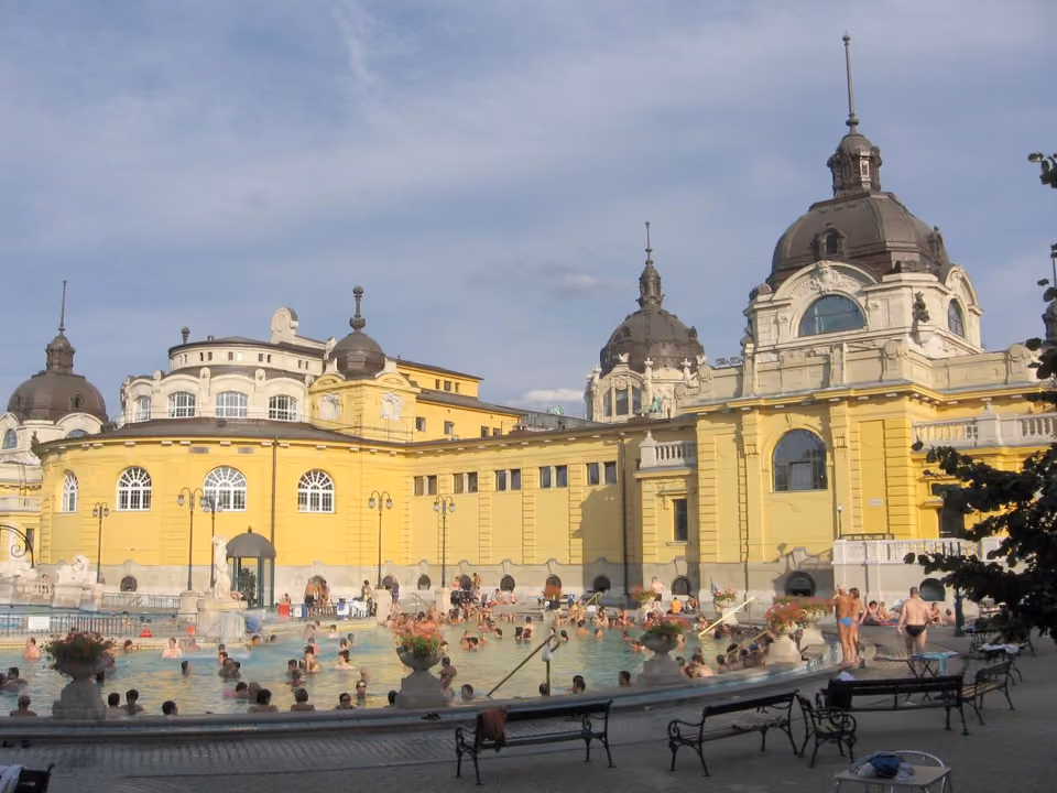 Piscina termal ao ar livre do balneário Széchenyi em Budapeste, com o prédio amarelo neobarroco ao redor