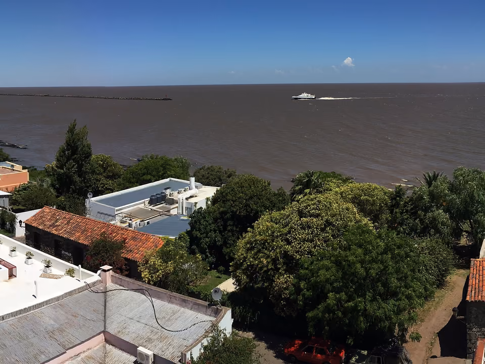 Vista panorâmica dos telhados coloniais do Barrio Histórico de Colonia del Sacramento, com o Río de la Plata ao fundo
