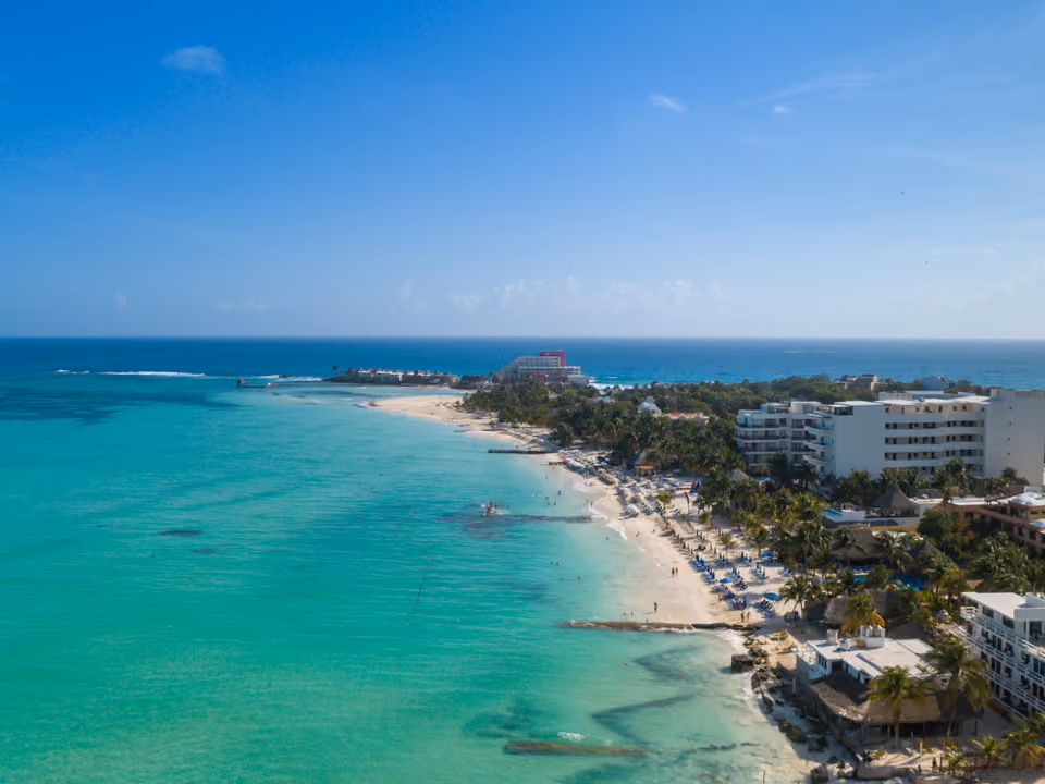 Playa Norte, em Isla Mujeres, com água rasa turquesa, areia branca fina e coqueiros inclinados sobre a praia