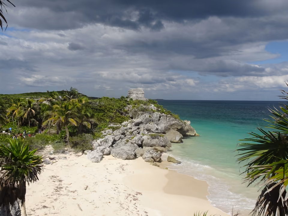 Ruínas maias de Tulum no alto de um penhasco à beira-mar, com o Templo do Deus Descendente e o mar Caribe turquesa ao fundo