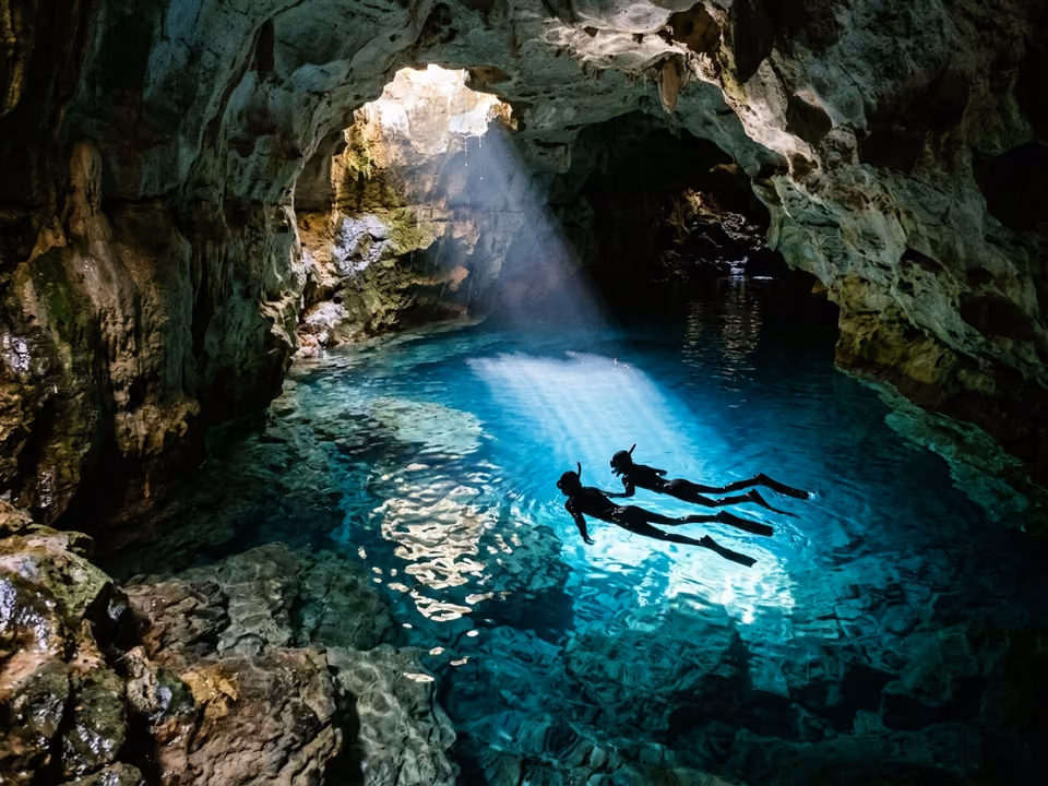 Silhuetas de flutuação no Poço Azul, água azul transparente iluminada pelo raio de sol da abertura da caverna