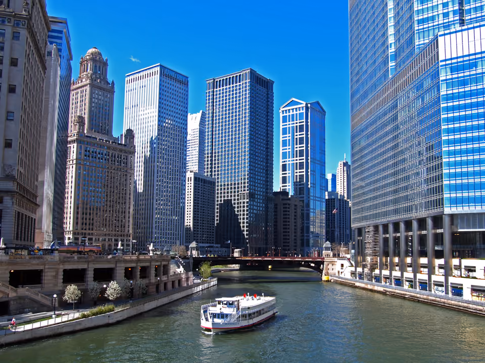 Barco de cruzeiro de arquitetura navegando pelo Chicago River, com os arranha-céus históricos ao longo das margens