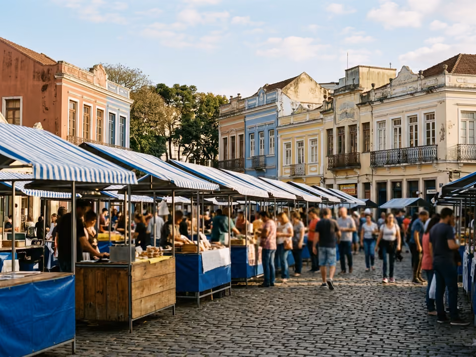 Barracas de lona listrada da feira de domingo no calçamento de pedra do Largo da Ordem, entre casarões históricos