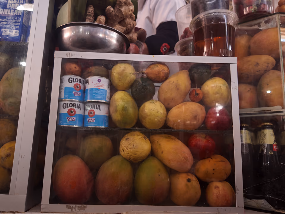 Barracas de frutas coloridas no Mercado Central de San Pedro, em Cusco, com produtos andinos expostos