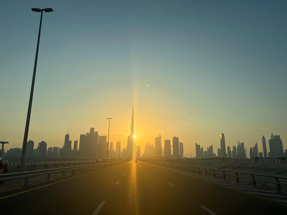 Silhueta do Burj Khalifa contra o pôr do sol, visto de uma rodovia de Dubai