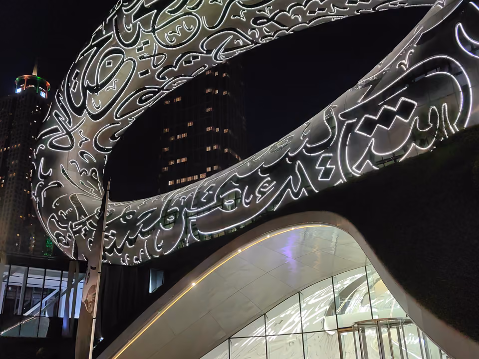 Fachada em anel do Museu do Futuro, em Dubai, coberta por caligrafia árabe iluminada à noite