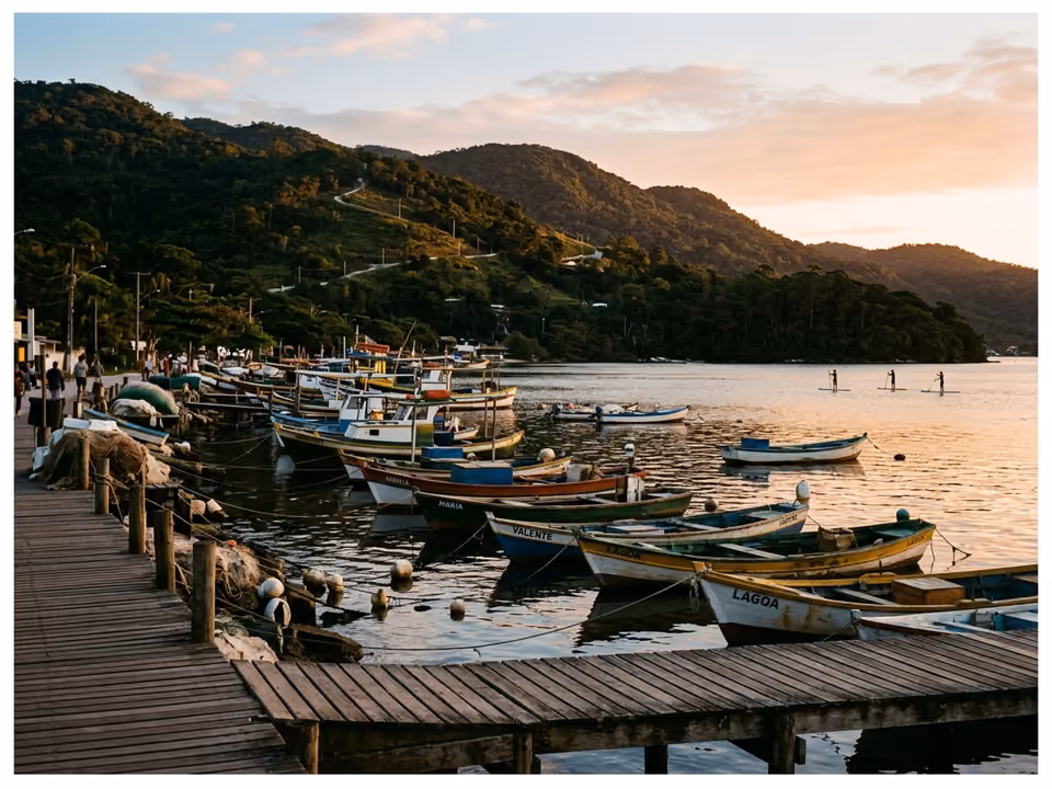 Orla da Lagoa da Conceição com barcos atracados e morros de mata ao redor