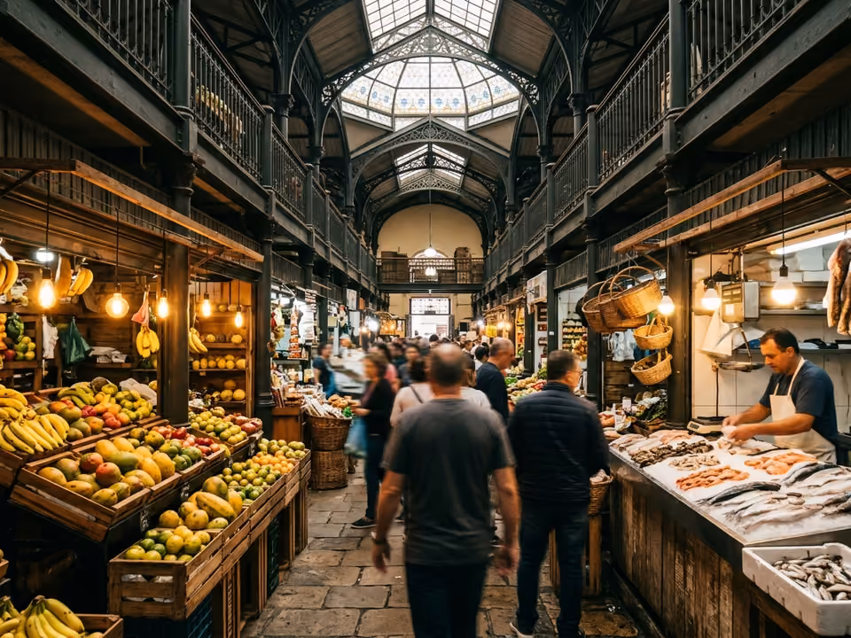 Interior do Mercado Público com estrutura de ferro, bancas de frutas e peixe sob luzes quentes