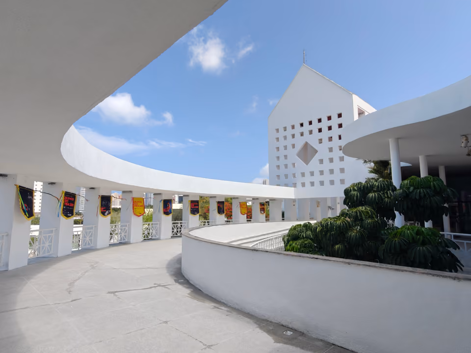Passarela curva de concreto do Centro Dragão do Mar de Arte e Cultura, em Fortaleza, com bandeirolas nos pilares