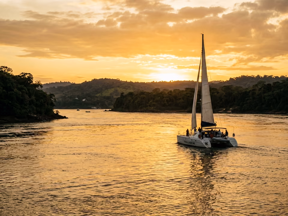 Catamarã navegando o rio Paraná dourado ao pôr do sol perto do encontro dos rios