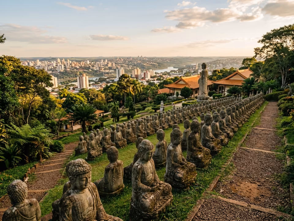 Fileiras de estátuas de Buda no jardim do templo, com a cidade de Foz do Iguaçu ao fundo