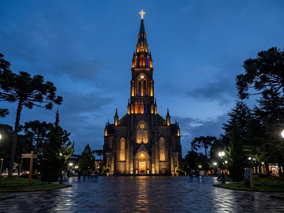 Fachada gótica da Catedral de Pedra de Canela iluminada à noite, vista da Praça da Matriz