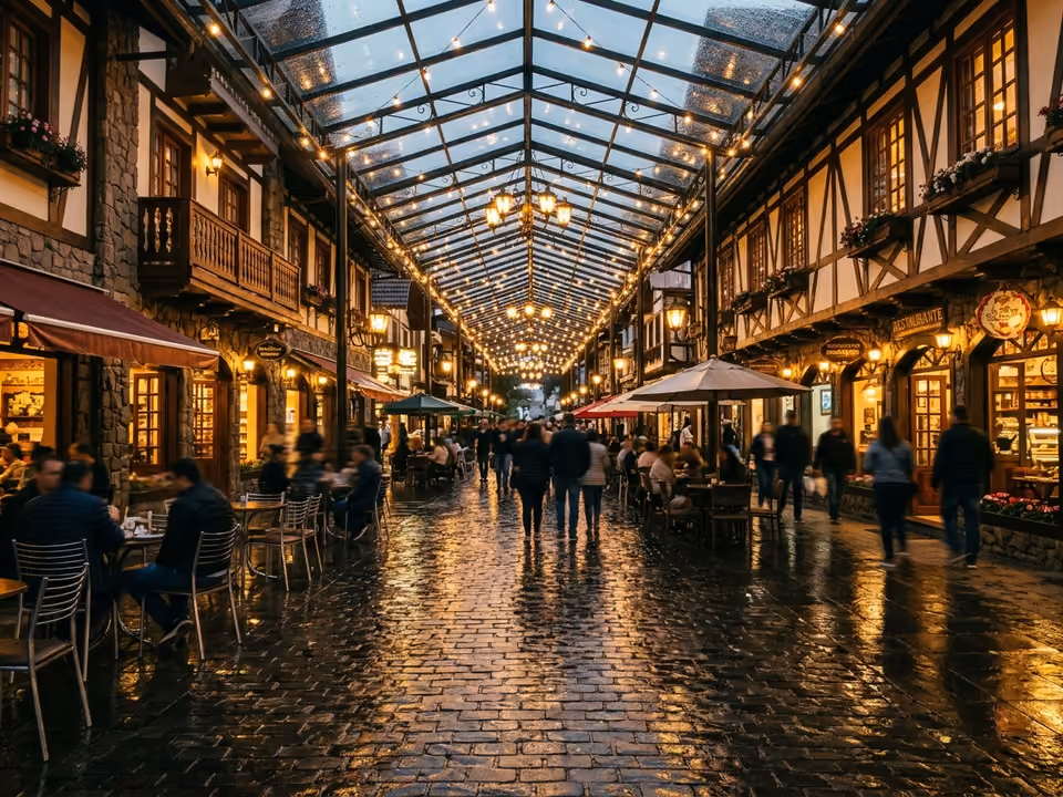 Rua Coberta de Gramado à noite, com a estrutura envidraçada iluminada sobre as mesas dos cafés
