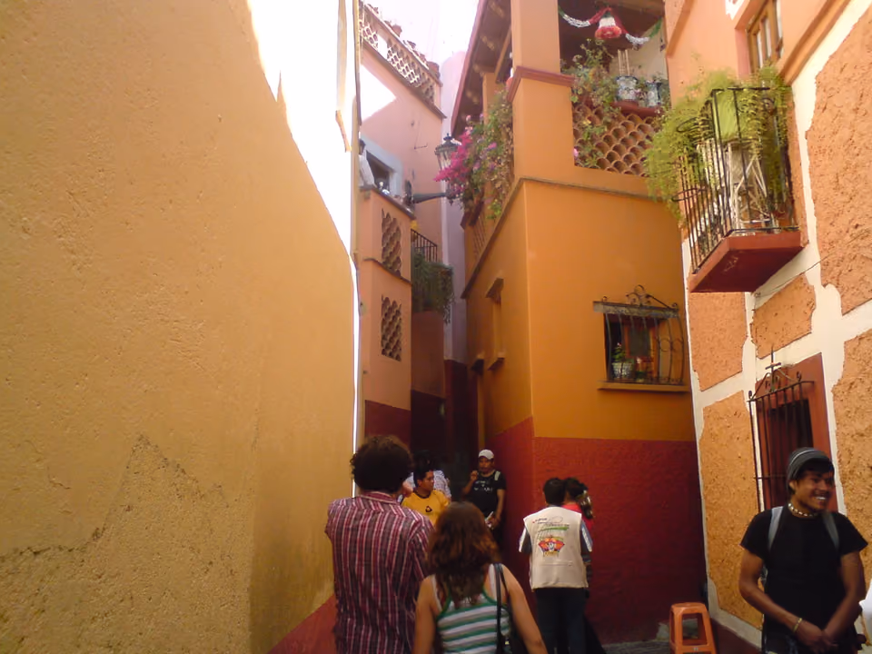 Turistas caminhando pelo estreito Callejón del Beso, em Guanajuato, México