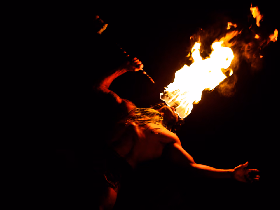 Artista realizando dança do fogo à noite, apresentação tradicional comum em luaus havaianos