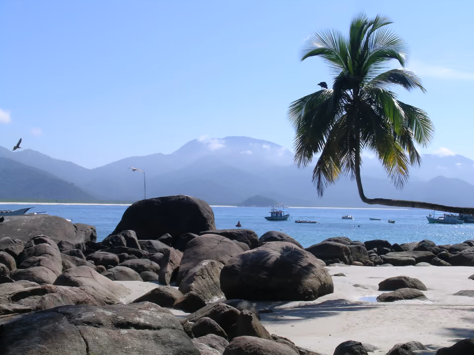Praia do Aventureiro com formações rochosas na água e vegetação nativa ao redor