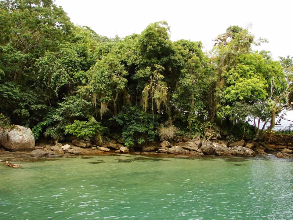 Barco de passeio ancorado em baía de água cristalina na Ilha Grande