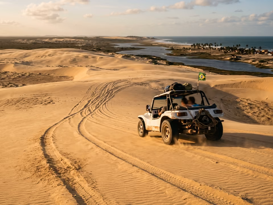 Buggy cruzando as dunas douradas do litoral leste de Jericoacoara, com lagoas e o mar ao fundo