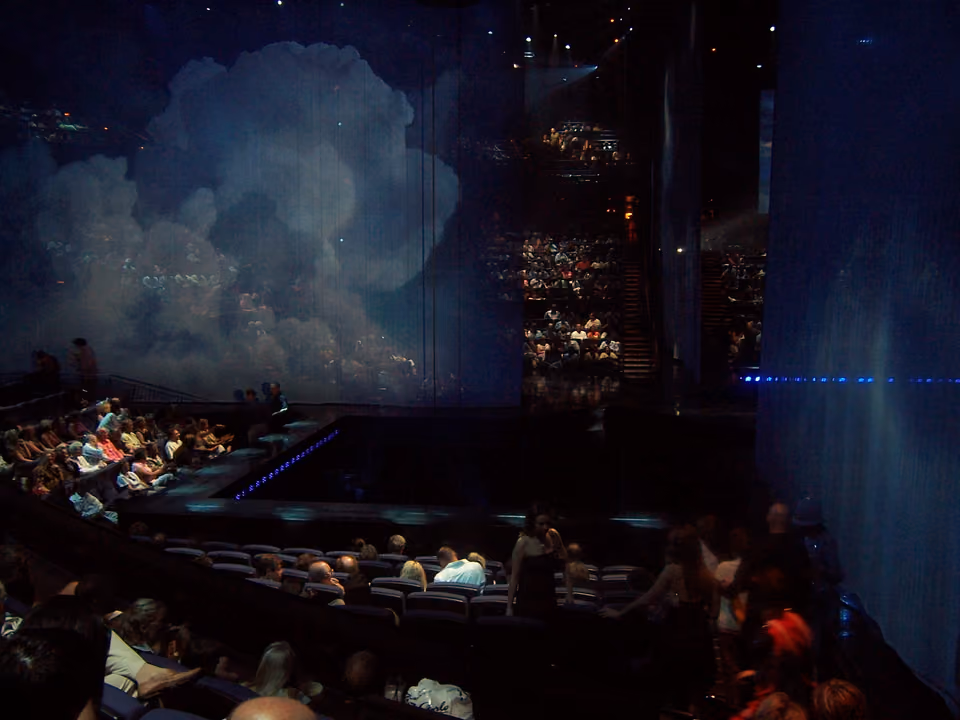Apresentação acrobática de um show do Cirque du Soleil em Las Vegas, com artistas suspensos no ar sob luz colorida