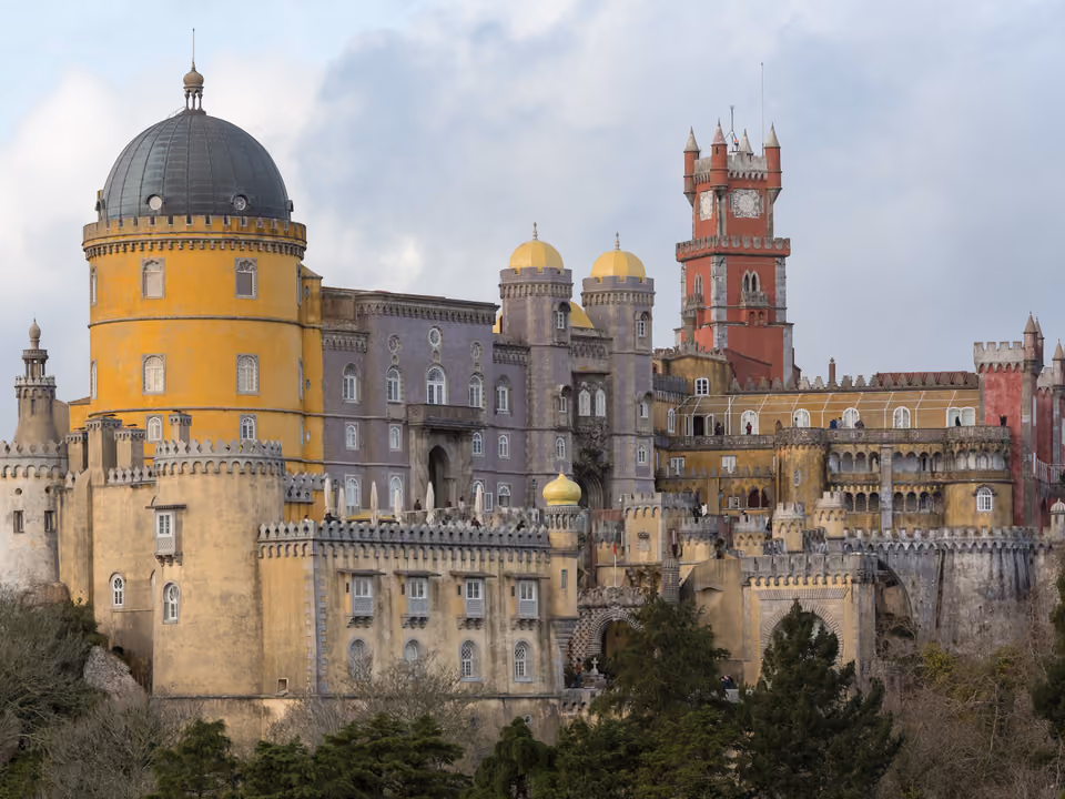 Palácio da Pena em Sintra, castelo romântico pintado de vermelho e amarelo no alto da serra, cercado de floresta