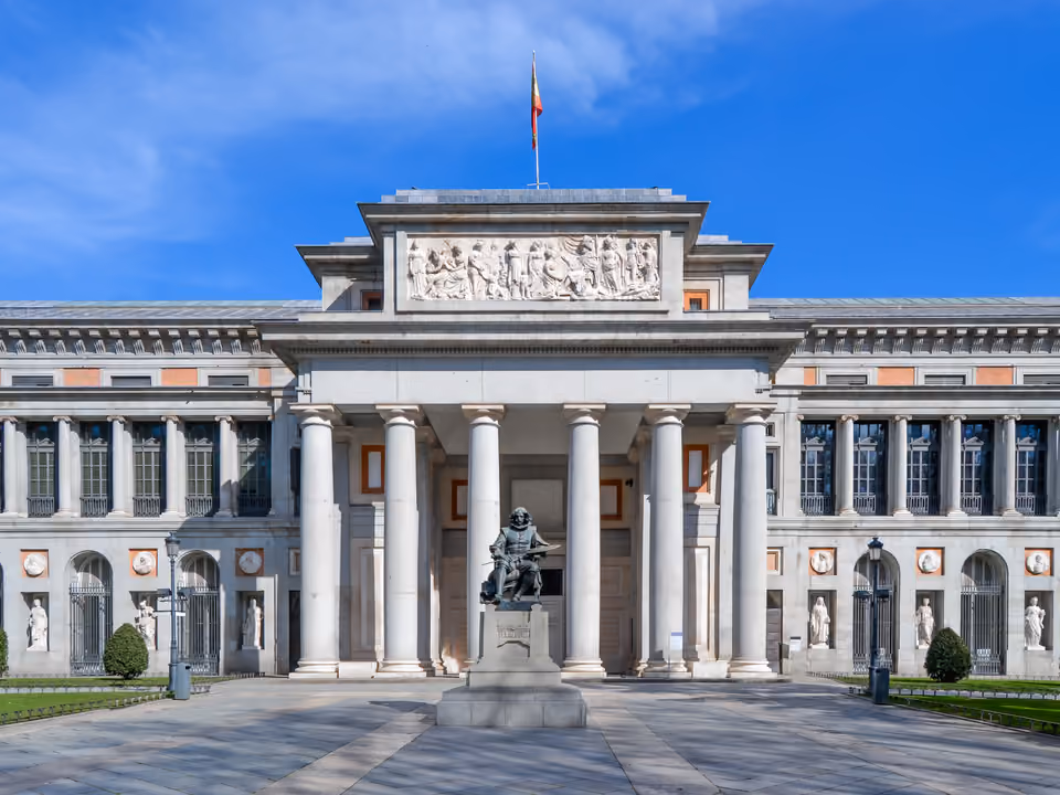 Pórtico neoclássico da Puerta de Velázquez do Museu do Prado em Madri, com a estátua de bronze de Velázquez em frente à entrada