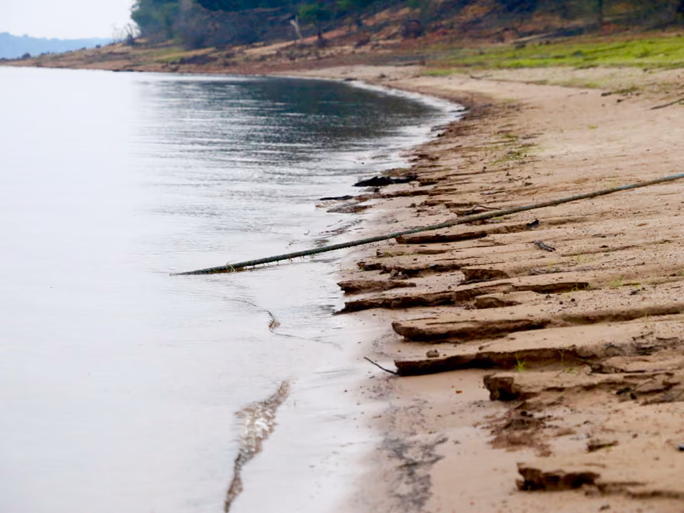 Praia de areia clara às margens de um canal do Arquipélago de Anavilhanas, no Rio Negro, cercada de floresta