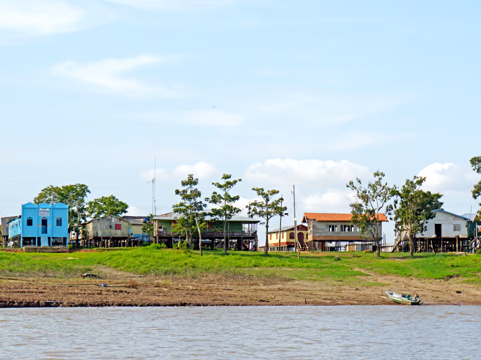 Casas de palafita de uma comunidade ribeirinha às margens de um rio na Amazônia, moradia típica de condutores locais