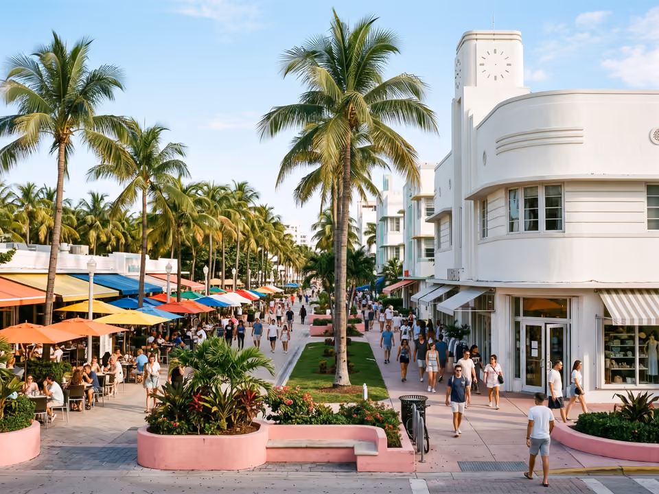 Calçadão da Lincoln Road Mall com palmeiras, mesas de café e um prédio Art Deco curvo na esquina