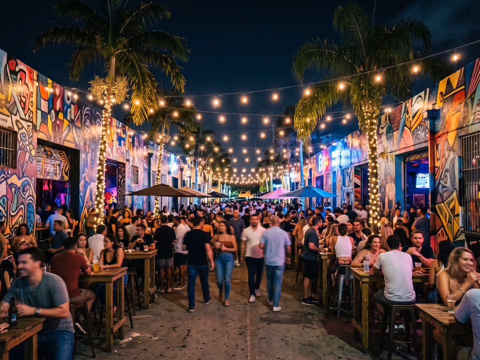 Bar ao ar livre em Wynwood à noite, com luzes penduradas e murais coloridos iluminados