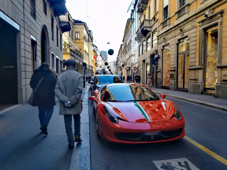 Via Monte Napoleone, no Quadrilatero da Moda, com palácios e vitrines de grife dos dois lados, decoração de fim de ano suspensa e um carro esportivo estacionado