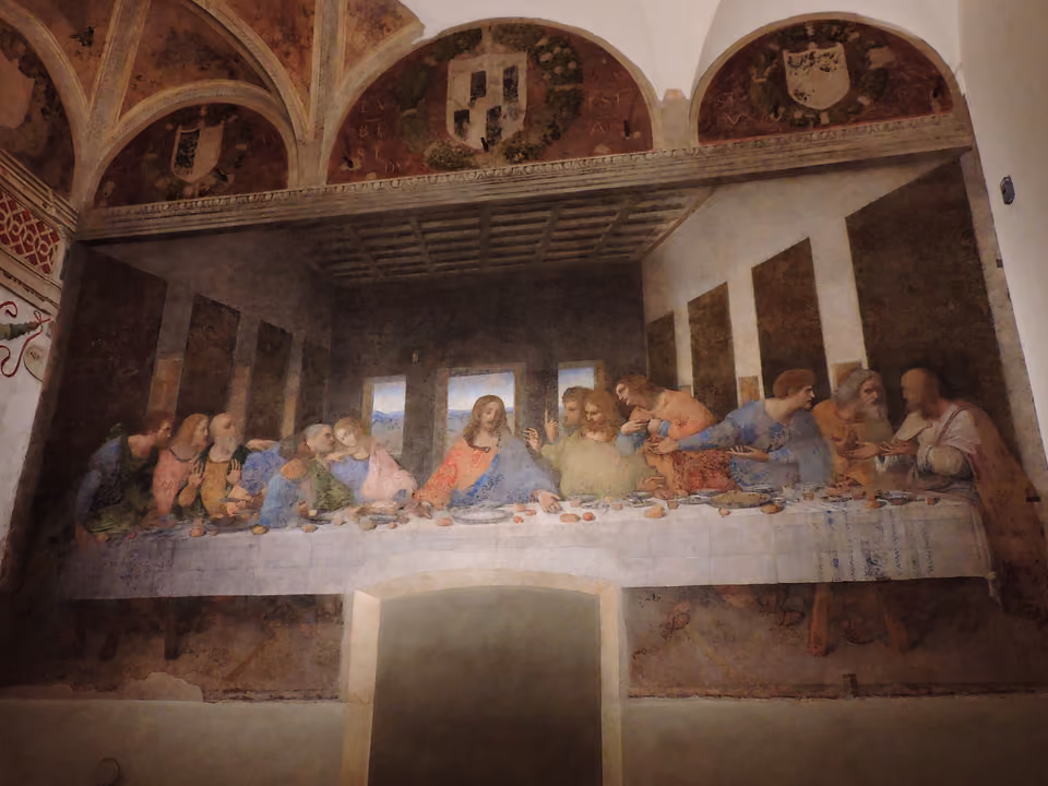O mural da Última Ceia de Leonardo da Vinci na parede do antigo refeitório de Santa Maria delle Grazie, com as lunetas brasonadas acima