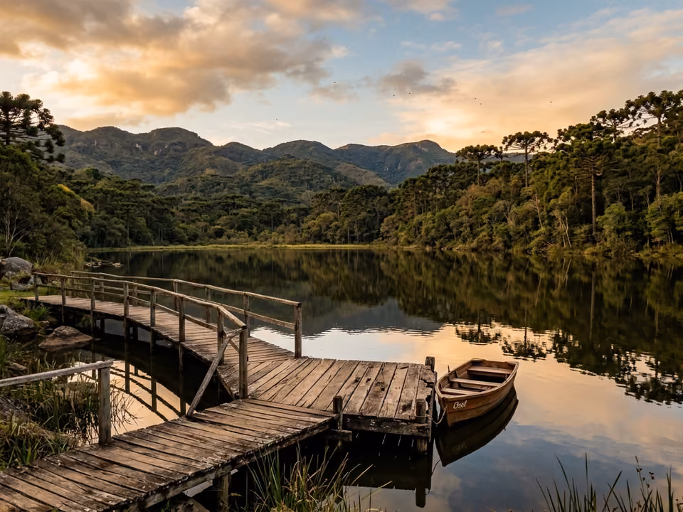 Lago calmo com deck de madeira e araucárias refletidas na água em parque de montanha