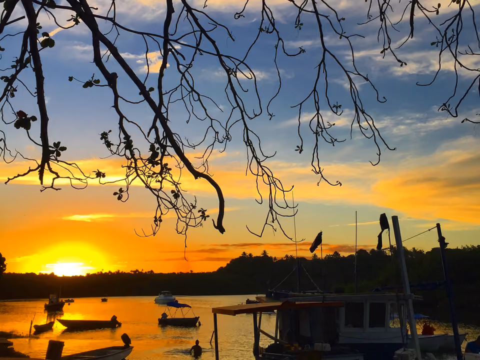 Pôr do sol sobre o mar no litoral sul da Bahia, com barco ancorado