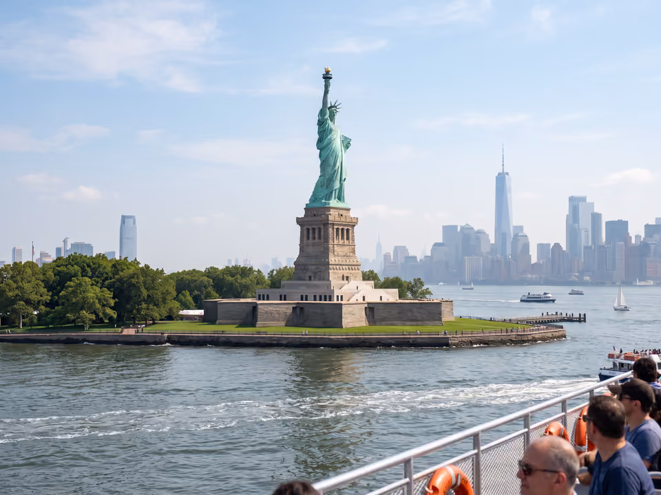 Estátua da Liberdade vista de um barco na baía de Nova York, com a tocha erguida contra o céu