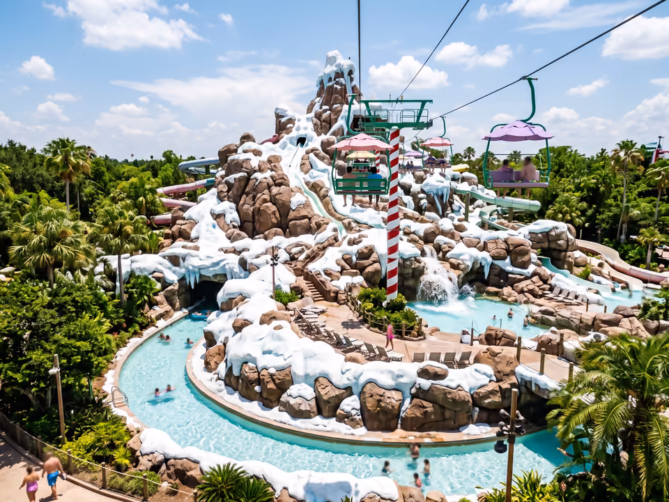 Montanha nevada do Blizzard Beach com teleférico de cadeiras coloridas sobre a piscina em formato de rio