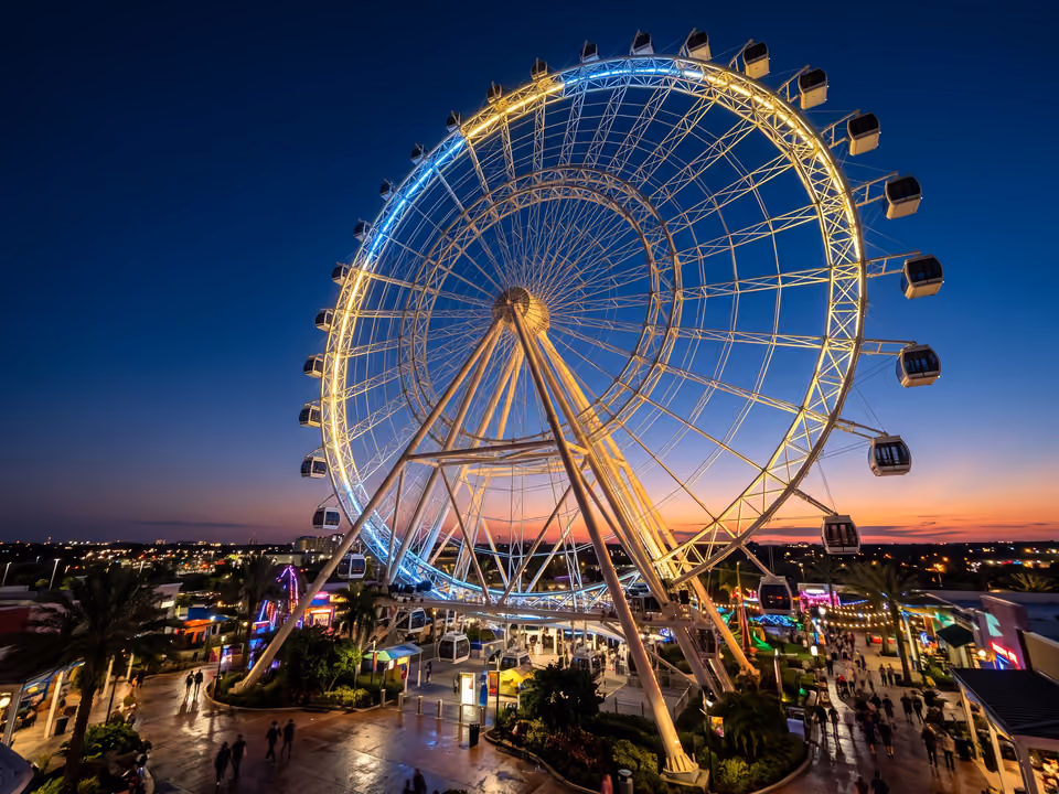 A roda-gigante do ICON Park iluminada ao entardecer, com cápsulas de vidro sobre estrutura treliçada