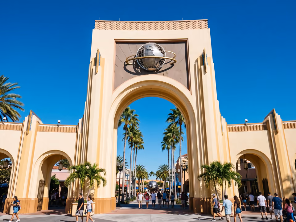 Arco de entrada do Universal Studios Florida, com o globo giratório sobre a passagem ladeada de palmeiras