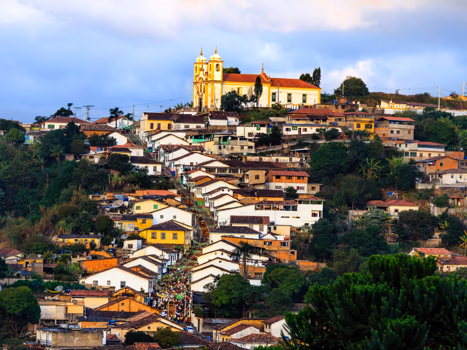 A Igreja de Santa Efigênia no alto do bairro do Alto da Cruz, em Ouro Preto, dominando os telhados coloniais que descem a encosta, em luz dourada de fim de tarde