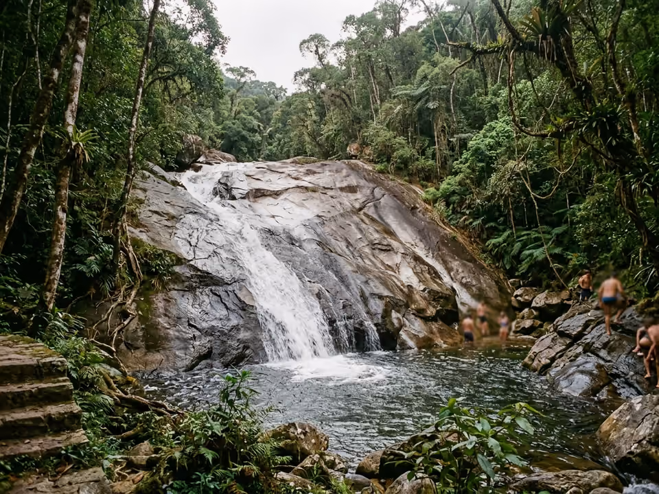 Laje de pedra lisa do Tobogã com água escorrendo para o poço natural cercado de mata