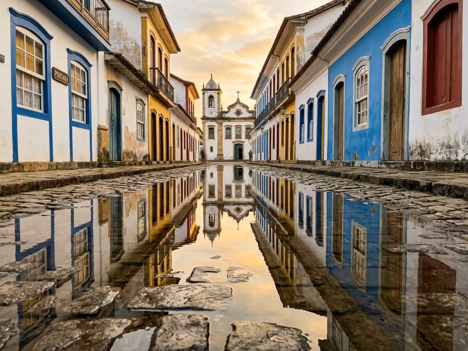 Rua de pedra do centro histórico alagada pela maré, refletindo os casarios coloniais e a igreja