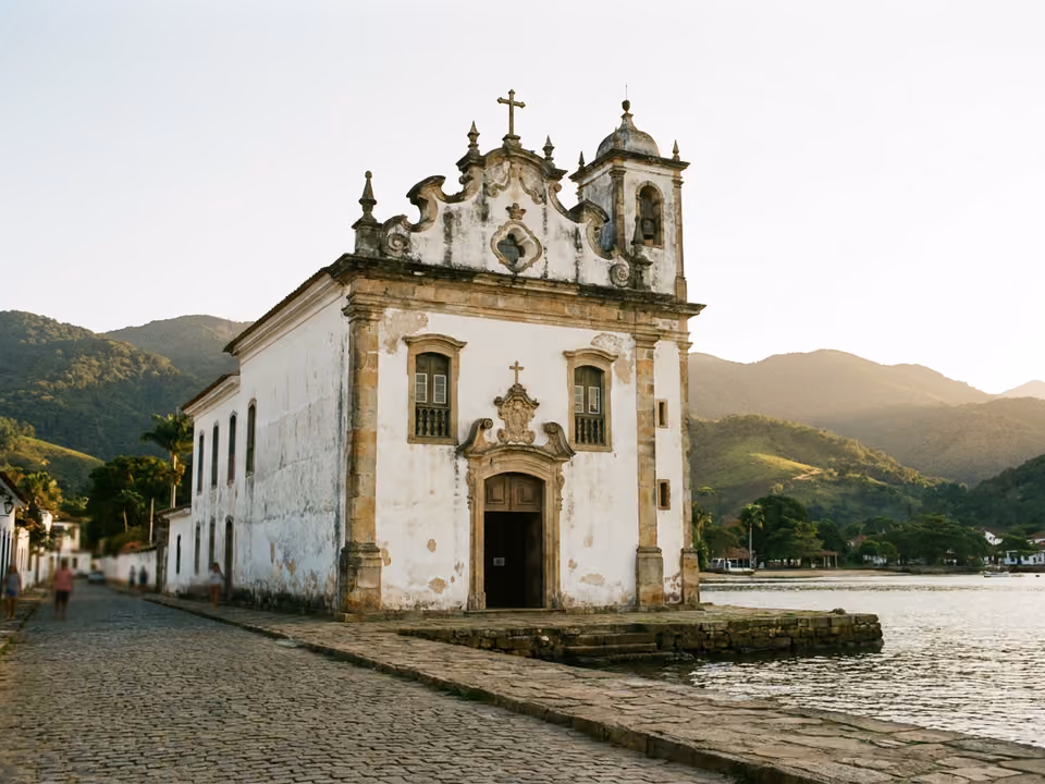 Fachada barroca branca da Igreja de Santa Rita contra a baía e os morros verdes